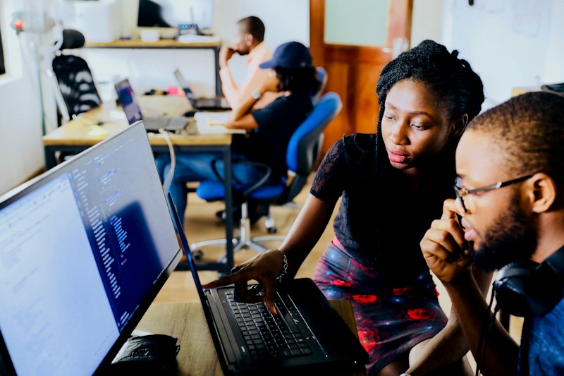 Software engineers pair programming and reviewing code on screen